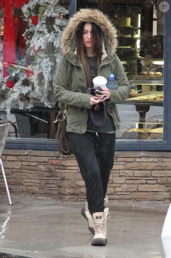 Trempée, Megan Fox se protège de la pluie à Los Angeles le 12 décembre 2011