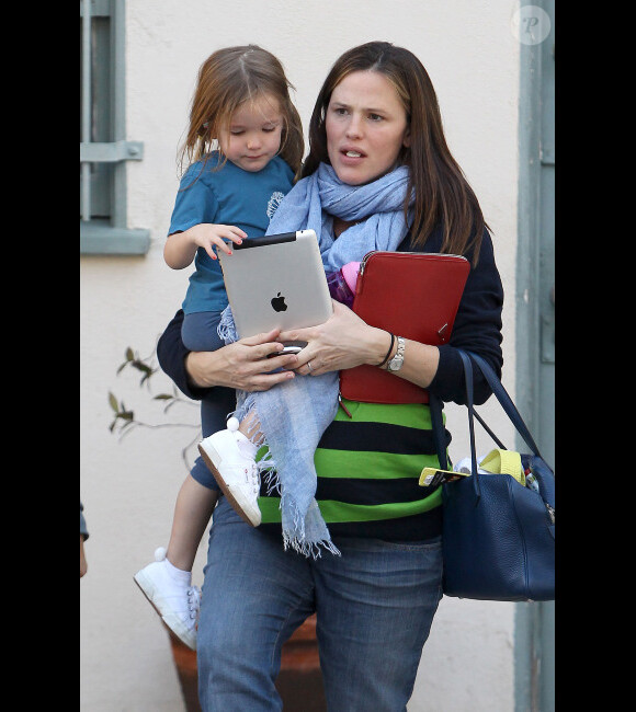 Jennifer Garner : Seraphina joue à l'Ipad dans les bras de sa maman après être allée chercher Violet à son cours de karaté à Los Angeles le 17 février 2012