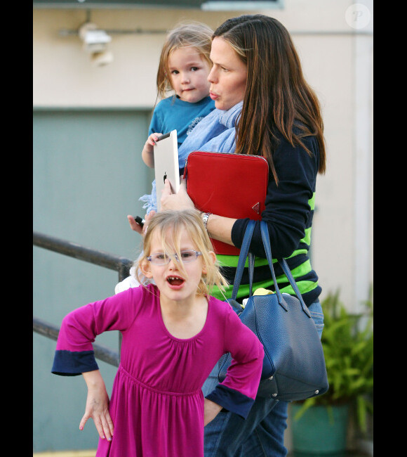 Jennifer Garner : Seraphina joue à l'Ipad dans les bras de sa maman après être allée chercher Violet à son cours de karaté à Los Angeles le 17 février 2012