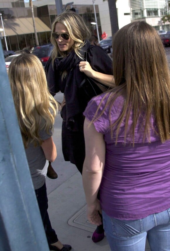 Molly Sims rencontre des amis à la sortie d'un restaurant et en profite pour engager la discussion. Los Angeles, le 17 février 2012.