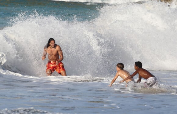 Joakim Noah s'éclate dans les vagues avec deux jeunes fans le 23 février 2012 à Saint-Barthélémy