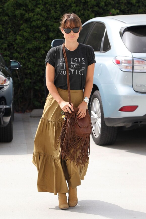 L'actrice Olivia Wilde se la joue hippie avec sa longue robe, accessoirisée d'une paire de bottes et d'un sac à franges.