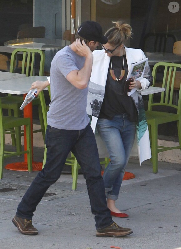 Drew Barrymore tente de cacher son ventre de femme enceinte sous un improbable manteau, en compagnie de son fiancé Will Kopelman, le 20 avril 2012 à Beverly Hills