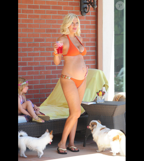Tori Spelling pose au milieu de ses chiens le 3 mai 2012 dans sa demeure de Malibu avec sa petite fille Stella