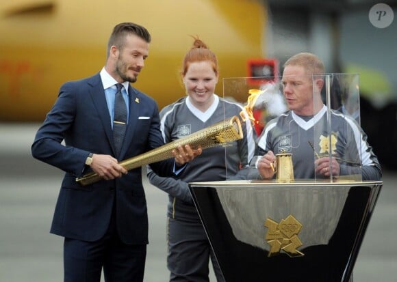 David Beckham, très fier, a embrasé à la base d'aéronautique navale de Culdrose (Cornouailles) une vasque avec la flamme olympique rapportée d'Athènes par la délégation des JO de Londres 2012, vendredi 18 mai 2012.
