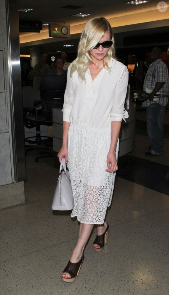 Kirsten Dunst adopte une très jolie robe chemise plissée avec de la dentelle pour voyager. A à l'aéroport de Los Angeles. Le 26 mai 2012.