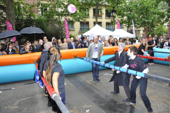 Zinedine Zidane et Sophie Thalmann s'essaient au babyfoot géant le 7 juin 2012 lors d'une journée de mobilisation organisée par ELA dans les rues de Paris près du Parc Monceau