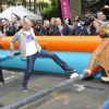 Zinedine Zidane et Sophie Thalmann s'essaient au babyfoot géant le 7 juin 2012 lors d'une journée de mobilisation organisée par ELA dans les rues de Paris près du Parc Monceau