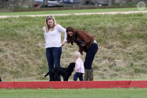 Kate Middleton, duchesse de Cambridge, assiste avec son chien Lupo à un match caritatif de polo auquel les princes William et Harry participent, à Westonbirt, le 17 juin 2012. Ici avec la petite Savannah, fille de Peter et Autumn Phillips