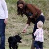 Kate Middleton, duchesse de Cambridge, assiste avec son chien Lupo à un match caritatif de polo auquel les princes William et Harry participent, à Westonbirt, le 17 juin 2012. Ici avec la petite Savannah, fille de Peter et Autumn Phillips. Elle lui donne une leçon de dressage canin.