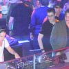 Pierre Sarkozy, alias DJ Mosey, mixe pendant que ses frères Louis et Jean l'observent lors de la soirée au Queen, boîte de nuit des Champs-Elysées à Paris, le 22 juin 2012