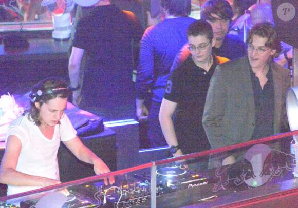 Pierre Sarkozy, alias DJ Mosey, mixe pendant que ses frères Louis et Jean l'observent lors de la soirée au Queen, boîte de nuit des Champs-Elysées à Paris, le 22 juin 2012