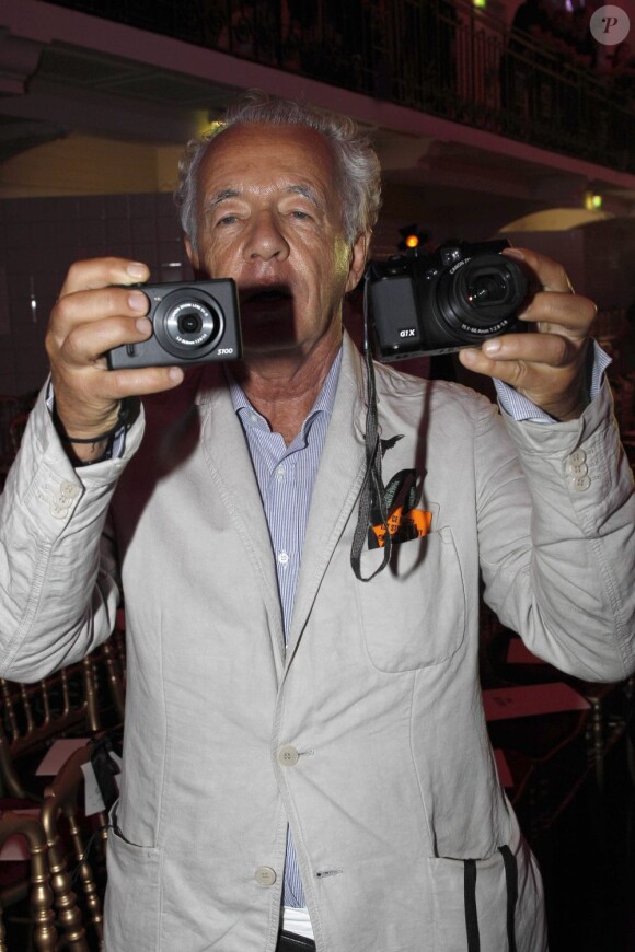 Le photographe Gilles Bensimon, opérationnel avec ses deux appareils photo à la main lors du défilé haute couture de Jean Paul Gaultier. Paris, le 4 juillet 2012.