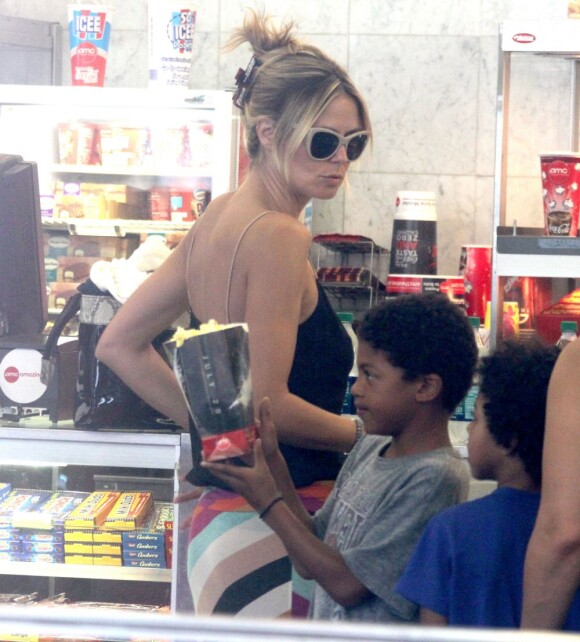 Passage en caisse pour Heidi Klum, qui commande des confiseries pour ses quatre enfants avec qui elle va voir un film. New York, le 10 juillet 2012.