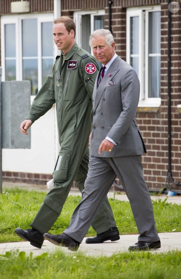 Père et fils d'un même pas. Visite guidée de la base de la RAF Valley à Anglesey pour le prince Charles, par son fils le prince William, capitaine au sein du 22e escadron, le 9 juillet 2012, au premier jour de sa tournée au Pays de Galles.