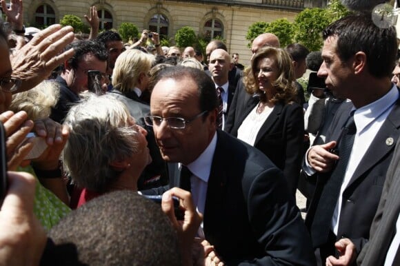 François Hollande et Valérie Trierweiler à sa suite dans les jardins de l'Elysée le 14 juillet 2012, le temps d'une brève rencontre avec le public.