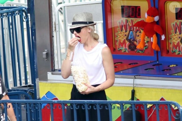 Pendant que ses fils sont sur les manèges, Gwen Stefani s'offre du popcorn. Central Park, New York, le 27 juillet 2012.