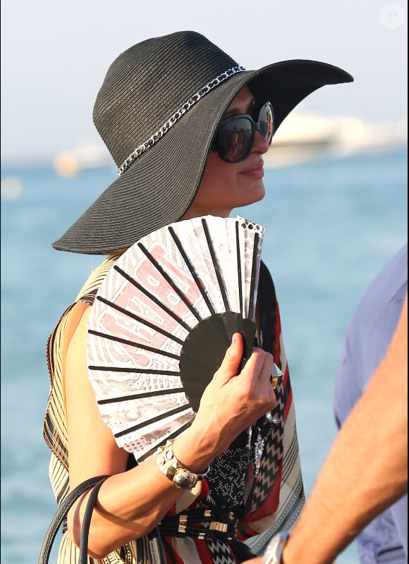 Sous son chapeau noire et éventail à la main, Paris Hilton se promène sur la plage de Pampelonne, à St-Tropez, le samedi 28 juillet 2012.