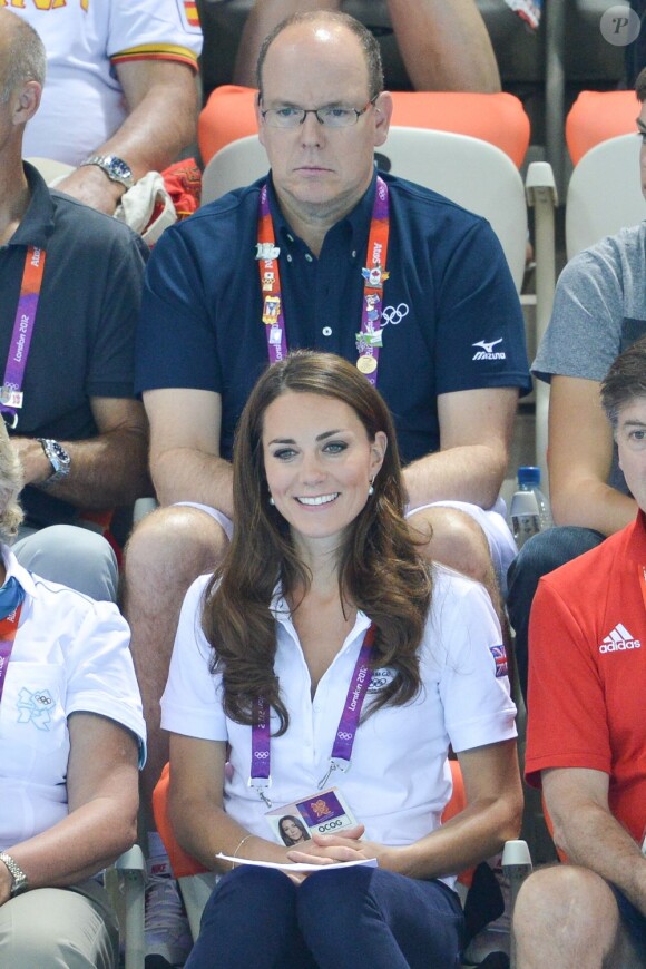 Kate Middleton, entre les anciennes gloires britanniques du patinage artistique Jenny Gray et Robin Cousins, dans les gradins de l'Aquatics Centre le 9 août 2012 pour soutenir et applaudir les nageuses britanniques en lice en natation synchronisée par équipes. La Grande-Bretagne a fini 6e.