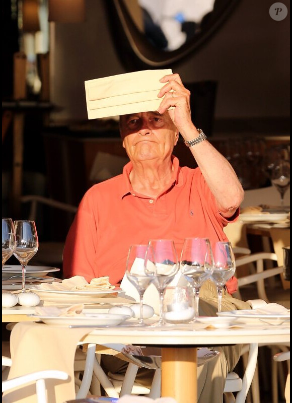 Jacques Chirac, tente de se protéger du soleil, à la terrasse du restaurant Le Girelier, à St-Tropez, le vendredi 10 août 2012.