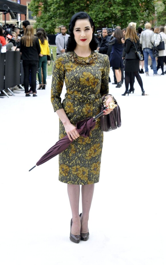 Dita Von Teese assiste au défilé Burberry Prorsum printemps-été 2013 à Kensington Gardens, habillée d'une robe de la marque collection automne 2012. Londres, le 17 septembre 2012.