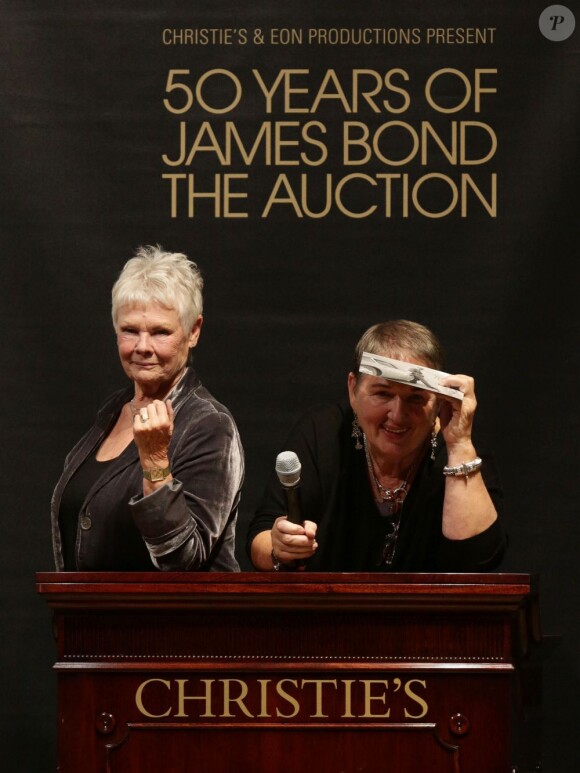 Dame Judi Dench était en pleine forme, et a plaisanté sur le maillot de bain La Perla de Daniel Craig dans Casino Royale. Vente aux enchères d'objets de la saga James Bond donnés par les acteurs de la franchise, chez Christie's, à Londres, le 5 octobre 2012