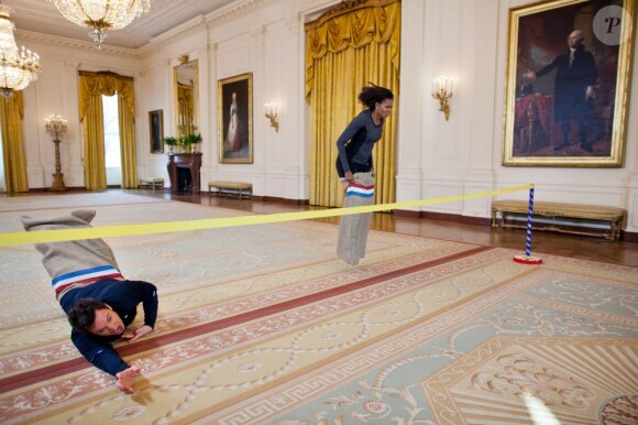 Michelle Obama en pleine course en sac avec Jimmy Fallon dans les couloirs de la Maison Blanche pour le second anniversaire de l'initiative Let's Move, à Washington, le 25 janvier 2012.