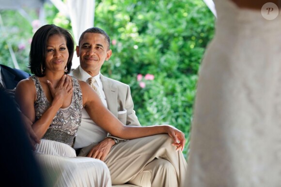 Michelle Obama émue et son époux Barack Obama durant le mariage de Laura Jarrett, fille de la conseillère du président Valerie Jarrett, à Chicago, le 18 juin 2012.