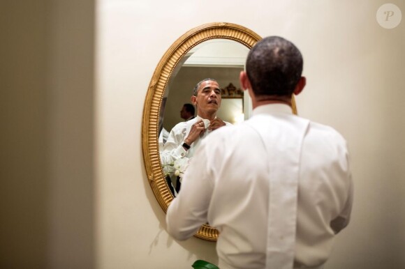 Barack Obama noue sa cravate devant un miroir de la Maison Blanche, le 18 octobre 2012.