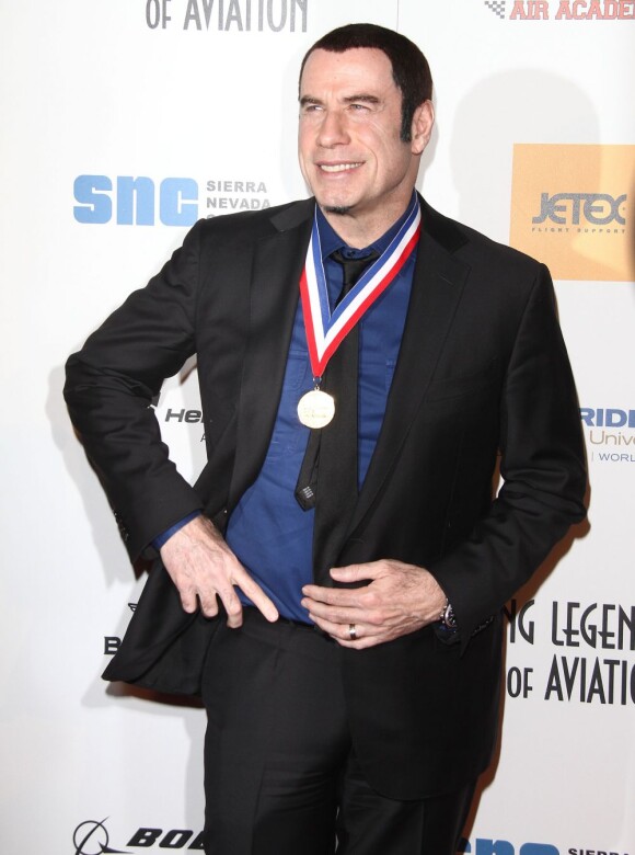 John Travolta pose avec sa médaille à la 10e cérémonie annuelle Living Legends of Aviation Awards à Beverly Hills, le 18 janvier 2013.