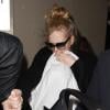 Arrivée tumultueuse de la chanteuse Adele qui essaie de protéger son nouveau-né des photographes et de la foule, à l'aéroport de Los Angeles, le 10 janvier 2013.