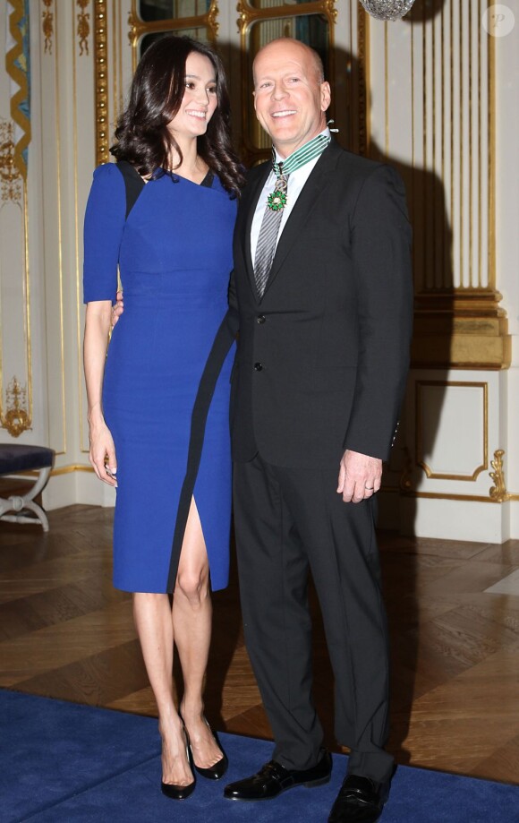 Bruce Willis reçoit les insignes de commandeur de l'ordre des Arts et des Lettres des mains d'Aurélie Filippetti, ministre de la Culture et de la Communication, avec sa femme Emma Heming, à Paris le 11 février 2013.