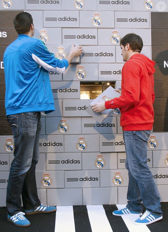 Iker Casillas et un joueur du Real Madrid lors de l'inauguration de la nouvelle boutique Adidas au stade Santiago Bernabeu de Madrid le 21 février 2013