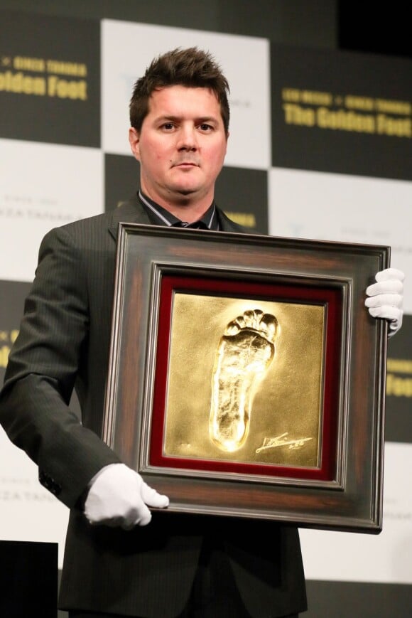 Le pied gauche de Lionel Messi immortalisé dans l'or et présenté le 6 mars 2013 à Tokyo par son frère, souriant