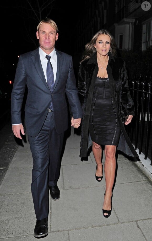 La comédienne Elizabeth Hurley et son compagnon, le sportif Shane Warne dans les rues de Londres le 12 mars 2013.