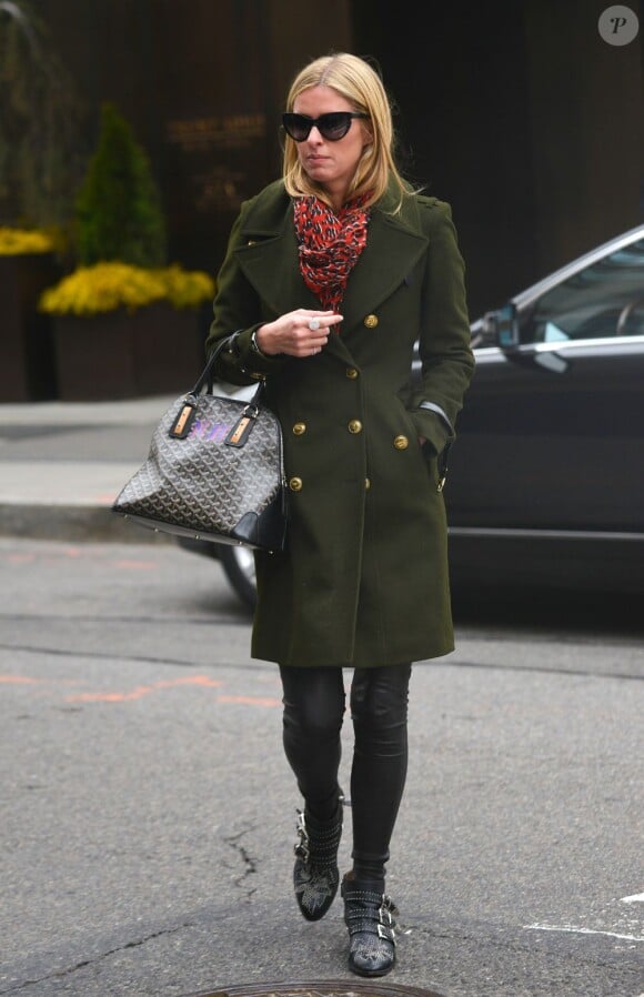 Nicky Hilton quitte son hôtel à New York, habillée d'un caban kaki, d'un pantalon en cuir et de bottines Chloé avec une écharpe Louis Vuitton et un sac Goyard. Le 21 mars 2013.