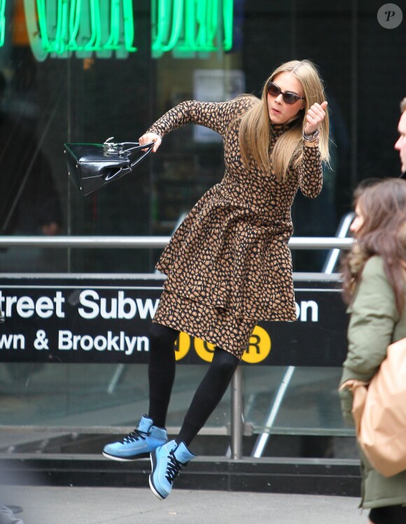 Cara Delevingne en robe à pois et baskets Nike Air Jordan sur son shooting photo pour DKNY à New York, le 21 mars 2013.