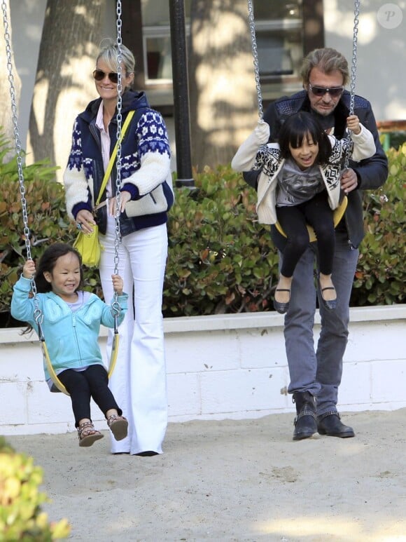 Johnny Hallyday, sa belle Laeticia et leurs filettes Jade et Joy profitent du soleil de Californie sur les balançoires d'un parc de Malibu, le 27 avril 2013