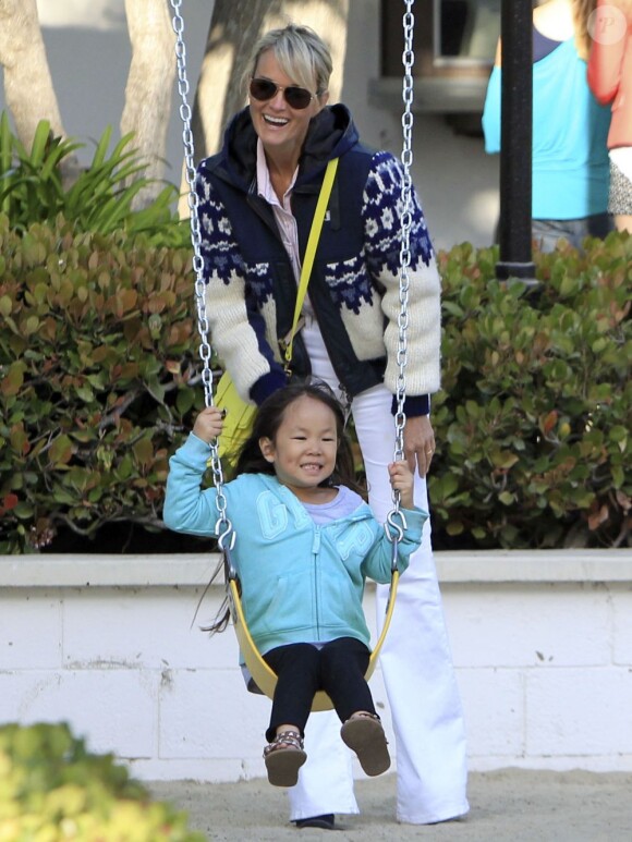 Johnny Hallyday, sa belle Laeticia et leurs filettes Jade et Joy profitent du soleil de Californie sur les balançoires d'un parc de Malibu, le 27 avril 2013