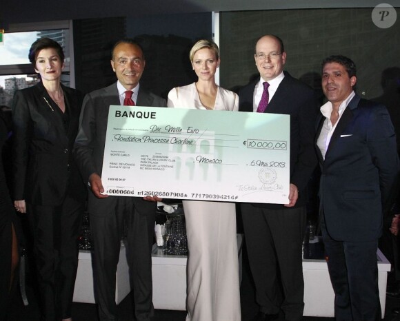 La princesse Charlene de Monaco recevant un don pour sa fondation à la soirée d'inauguration du club privé Italian Luxury Club au Zelos, au Forum Grimaldi, le 10 mai 2013.