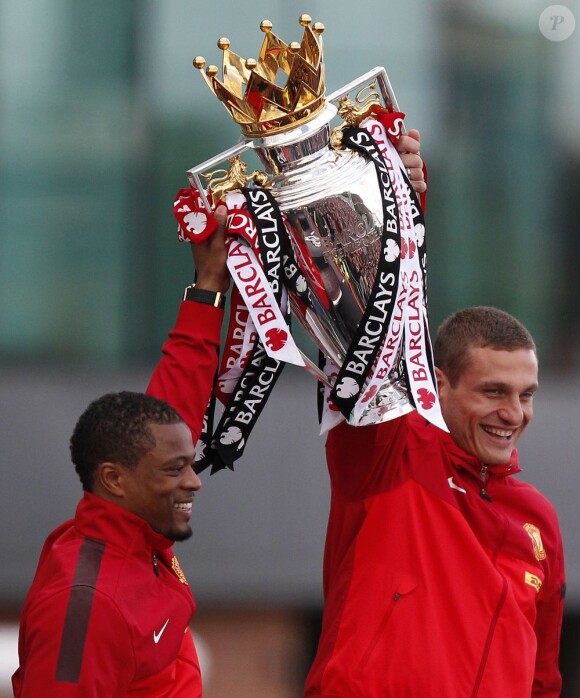 Les deux capitaines de Manchester United, Patrice Evra et Nemanja Vidic célèbrent le 20e titre de champion d'Angleterre au milieu des fans, à Manchester, le 13 mai 2013