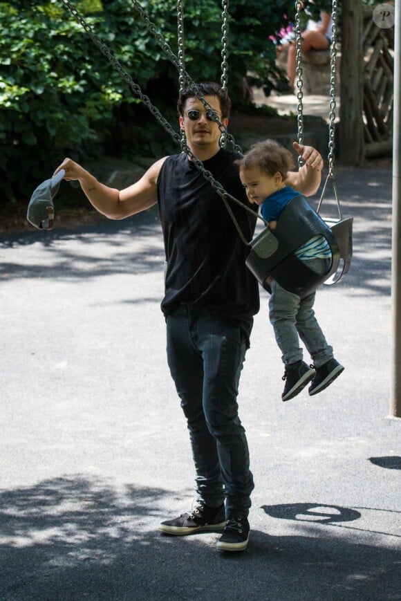Orlando Bloom profite du beau temps et s'amuse avec son fils Flynn dans un parc de New York City, le 6 juillet 2013.