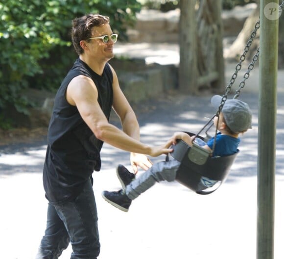 Le comédien britannique Orlando Bloom s'amuse avec son fils Flynn dans un parc de New York City, le 6 juillet 2013.