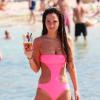 En monokini rose et rarement sans un verre à la main, Tulisa Contostavlos ne risque pas de passer inaperçue à la plage, en vacances à Ibiza le 10 juillet 2013