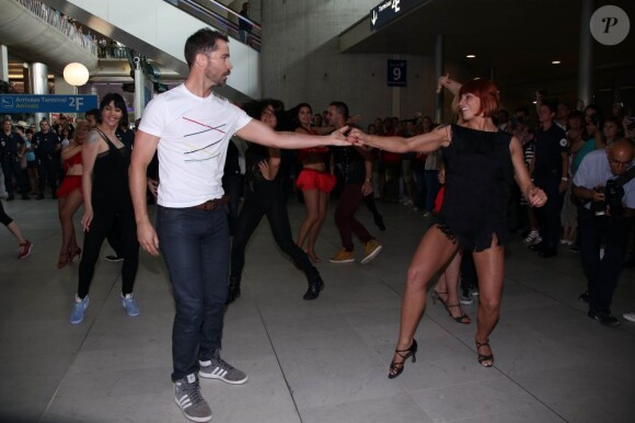 Emmanuel Moire et la danseuse Fauve Hautot en plein flashmob à l'aéroport de Roissy-Charles-de-Gaulle, le 12 juillet 2013.