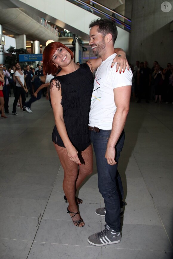 Emmanuel Moire et la danseuse Fauve Hautot, de l'émission Danse avec les stars à l'aéroport de Roissy-Charles-de-Gaulle, le 12 juillet 2013.