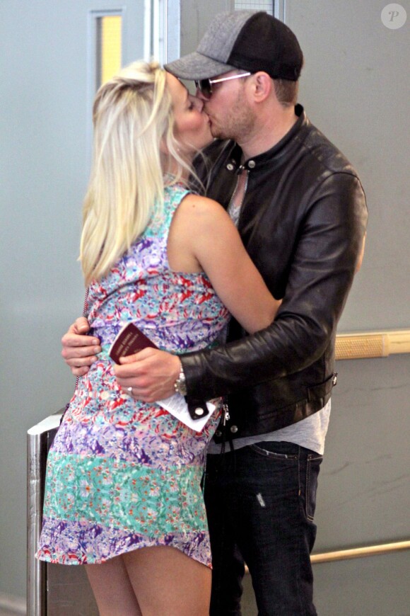 Michael Bublé embrasse sa femme Luisana Lopilato, enceinte de leur premier enfant, à son arrivée à l'aéroport de Vancouver, le 22 juillet 2013.
