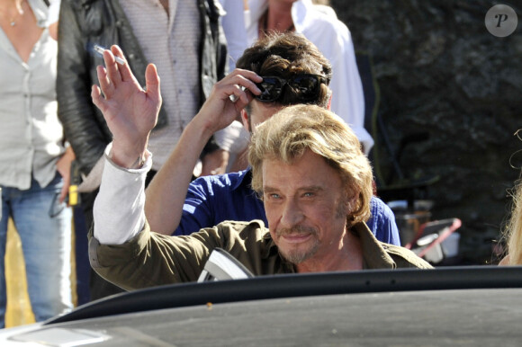 Johnny Hallyday salue la foule au dernier jour de tournage du film de Claude Lelouch "Salaud, on t'aime" à Saint-Gervais-les-Bains, le 31 juillet 2013.