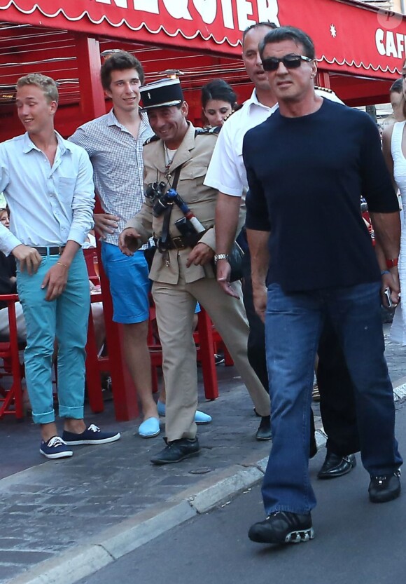 Un gendarme déguisé approche Sylvester Stallone au côté de sa femme Jennifer Flavin et ses filles Sophia, Sistine et Scarlet en vacances à Saint-Tropez le 3 août 2013.