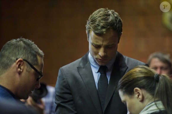 Oscar Pistorius prie avec son frère et sa soeur au tribunal de Pretoria le 19 août 2013.